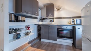 Eine moderne Küche mit Edelstahlgeräten, Holzböden und einem eingebauten Backofen.