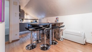 Eine moderne Küche mit einer zentralen Kochinsel, Barhocker und einem integrierten Kühlschrank.