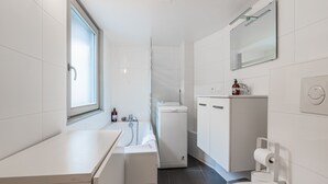 Ein modernes Badezimmer mit Toilette, Waschbecken und Duschbereich.