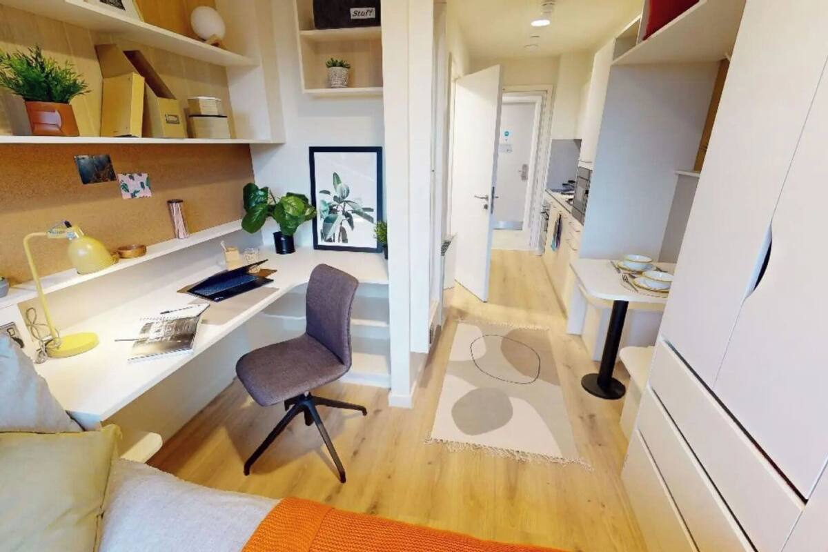 A compact living space with a desk, chair, and bed.