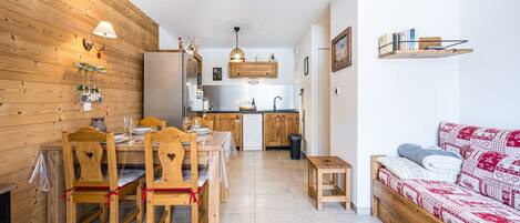 Un espace de vie compact comprenant un coin repas, une kitchenette et un canapé.