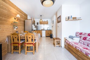 A compact living space with a dining area, kitchenette, and a sofa. - Chalets de Saint Pierre C102 - Appt avec balcon (Saint-Jean-de-Sixt)