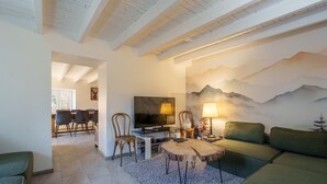 Un salon avec un téléviseur, une table basse en bois et un canapé.