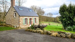 A stone house with a sloped roof, a chimney, and a small window. - Le Lotus - 1000 m² de jardin (Putanges-le-Lac)