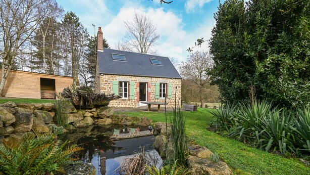 A stone house with a pond, green shutters, and a stone wall. - Le Lotus - 1000 m² de jardin (Putanges-le-Lac)