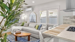 A modern living room with a sofa, coffee table, and a view of the outside.