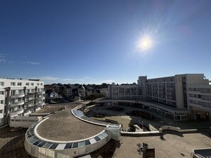 Ein moderner Gebäudekomplex mit einem zentralen Innenhof, umgeben von Wohngebäuden.