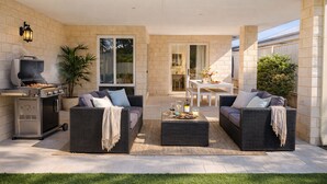 An outdoor patio with two wicker sofas, a dining table, and a barbecue grill. - Coastal retreat 2km from the beach (Golden Bay)