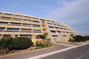 A modern building with multiple balconies and a curved facade. - L'ESCALE - Studio Héliopolis D 6 - Luxury - 2 people (AGDE)