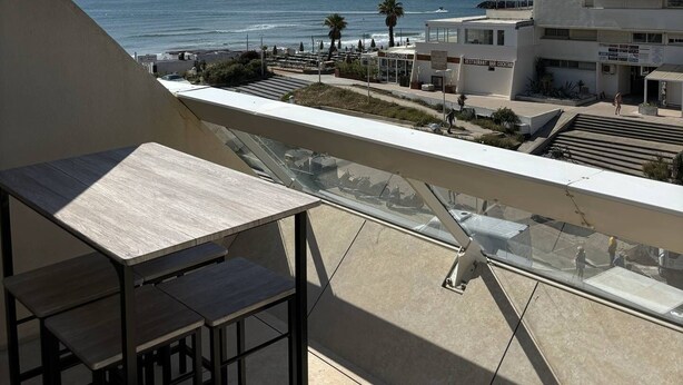 Een balkon met uitzicht op de oceaan en een restaurant genaamd "HORIZON" op de achtergrond.