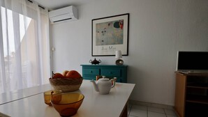 A room with a white table, a basket of oranges, a teapot, and a framed picture on the wall. - Studio Héliopolis D 51 - 4 people (AGDE)