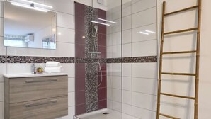 A modern bathroom with a glass shower enclosure, a vanity with a mirror, and a wooden ladder. - GENTLEMAN - Studio Héliopolis D 84 - Luxury - 2 people (AGDE)