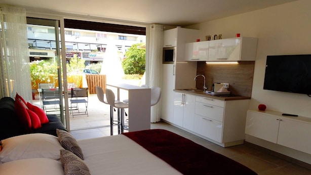 A modern hotel room with a bed, a small kitchenette, a dining area, and a TV. - GENTLEMAN - Studio Héliopolis D 84 - Luxury - 2 people (AGDE)