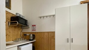 A compact kitchen with a microwave, kettle, and small refrigerator. - Deluxe Room with attached bathroom in Blackpool-Families and couples only (Blackpool)