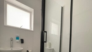 A bathroom with a glass-enclosed shower, a sink, and a toilet. - Deluxe Room with attached bathroom in Blackpool-Families and couples only (Blackpool)