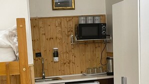 A compact kitchen with a microwave, a small refrigerator, and a sink. - Deluxe Room with attached bathroom in Blackpool-Families and couples only (Blackpool)