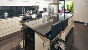 Cocina moderna con una isla central, electrodomésticos de acero inoxidable y vistas al exterior.