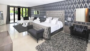 Un dormitorio moderno con una cama grande, un sofá y una mesa de comedor.