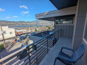 Ein Balkon mit Blick auf die Stadt, ein Tisch und ein Stuhl.