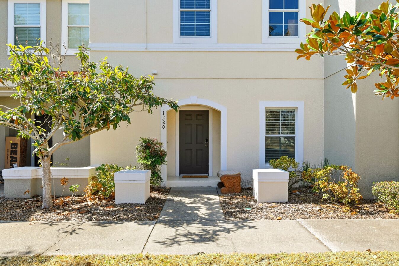 A two-story building with a front door, a small porch, and a mailbox.