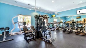 A gym with various exercise equipment, including treadmills and weight machines, and a ceiling fan. - Near Disney~Private Patio~Family~Bella Vida Resort (Kissimmee)