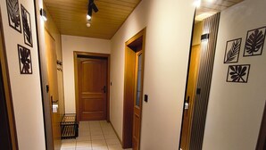 A hallway with a bench, a wooden door, and a large mirror reflecting the room. - Vacation apartment in Burghausen - castle magic near the world's longest castle (Burghausen)