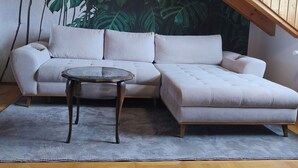 A modern living room with a sectional sofa, a glass coffee table, and a wooden floor. - Vacation apartment in Burghausen - castle magic near the world's longest castle (Burghausen)