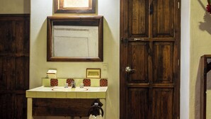 Ein Badezimmer mit Holztür, Waschbecken mit Spiegel und einem Handtuch an der Wand.