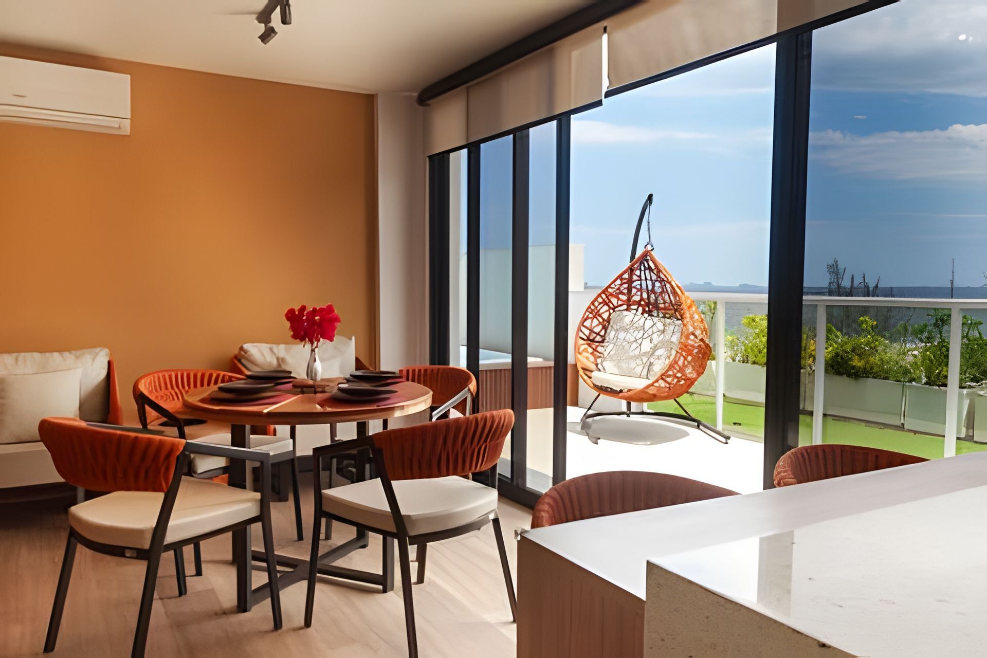A modern dining area with a round table, chairs, and a hanging chair.