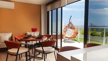A modern dining area with a round table, chairs, and a hanging chair.