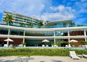 A modern hotel with a pool area, multiple balconies, and outdoor seating. - EXCLUSIVE APARTMENT IN PUNTA DE MITA (Corral del Risco)