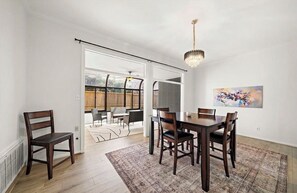 A dining area with a table and chairs, a chandelier, and a painting on the wall. - Luxe-Galleria. Terrific 3-bedroom house with AC in vibrant Houston (Houston)