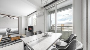 A modern hotel room with a large bed, a dining table, and a balcony with a view of the city. - GRANDIA 202 (Sapporo)