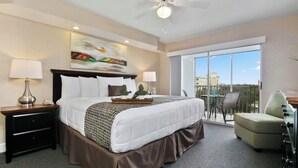 A hotel room with a large bed, a balcony with a chair, and a view of buildings. - Summer Disney Getaway, 2BR/2BA, sleeps 6, June 18-21, Resort Pool (Kissimmee)
