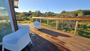 A wooden deck with two white plastic chairs and a wooden railing overlooking a grassy landscape. - Cozy Luxury Cabin in the De Luz Heights (Fallbrook)