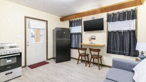 A compact kitchen with a stove, refrigerator, and a dining area with two chairs. - Spacious 2BR Apt Free Parking Baden (Baden)