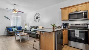 A modern kitchen with a built-in island, stainless steel appliances, and wooden cabinets. - Entire home in Gulfport, Mississippi (Gautier)