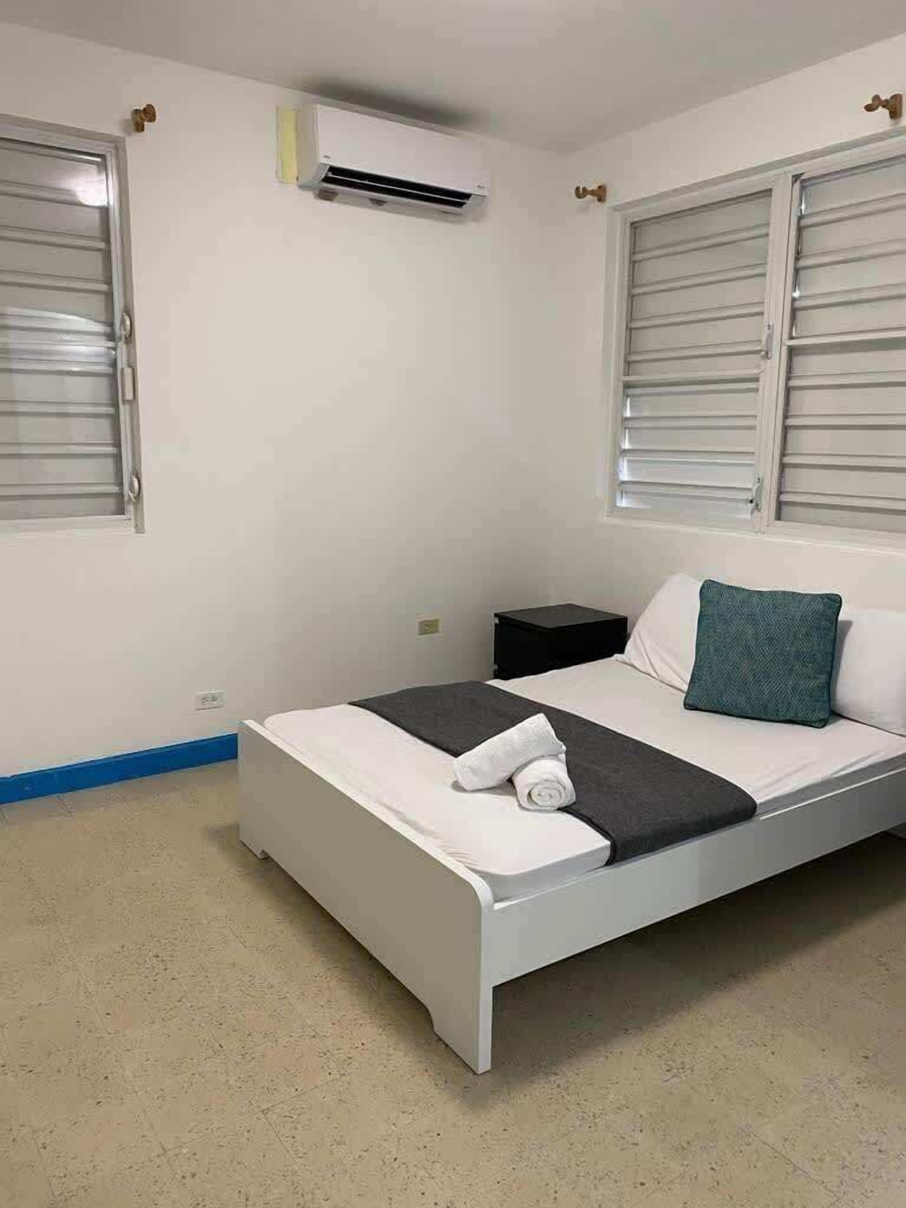 Ein Schlafzimmer mit einem Bett, einem Nachttisch und einer Klimaanlage.