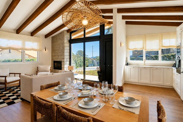 A dining area with a wooden table set for six, surrounded by wicker chairs. - Villa Inés · Llanes · Bungalow with a Garden (Cardoso (Llanes))