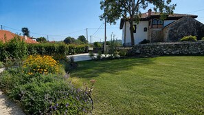 A well-maintained garden with a variety of flowers and a stone wall. - Villa Inés · Llanes · Single-story house with a garden (Cardoso (Llanes))