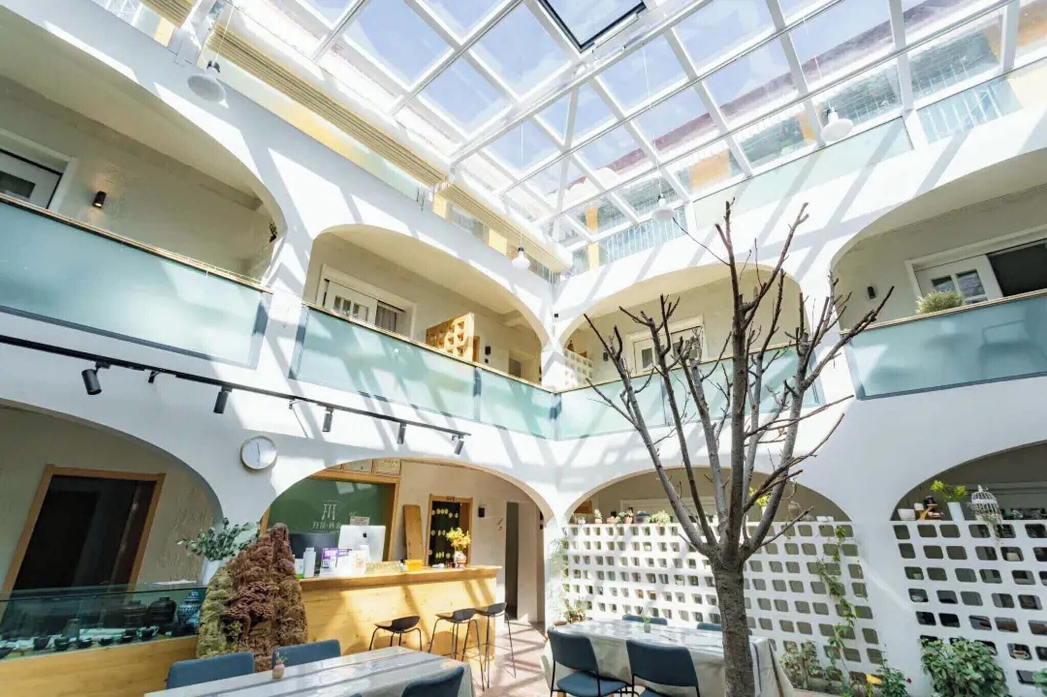 A multi-level atrium with glass railings, a reception desk, and seating areas.