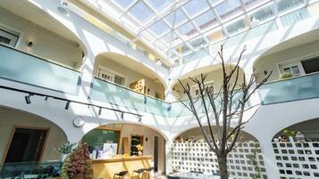 A multi-level atrium with glass railings, a reception desk, and seating areas.