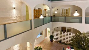 A multi-level interior with arched ceilings, wooden flooring, and a central seating area with plants. - TRANQUIL HOUSE (Lhasa)
