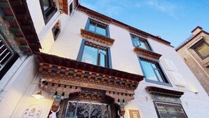 A building with a traditional facade, including a decorative entrance and multiple windows. - TRANQUIL HOUSE (Lhasa)