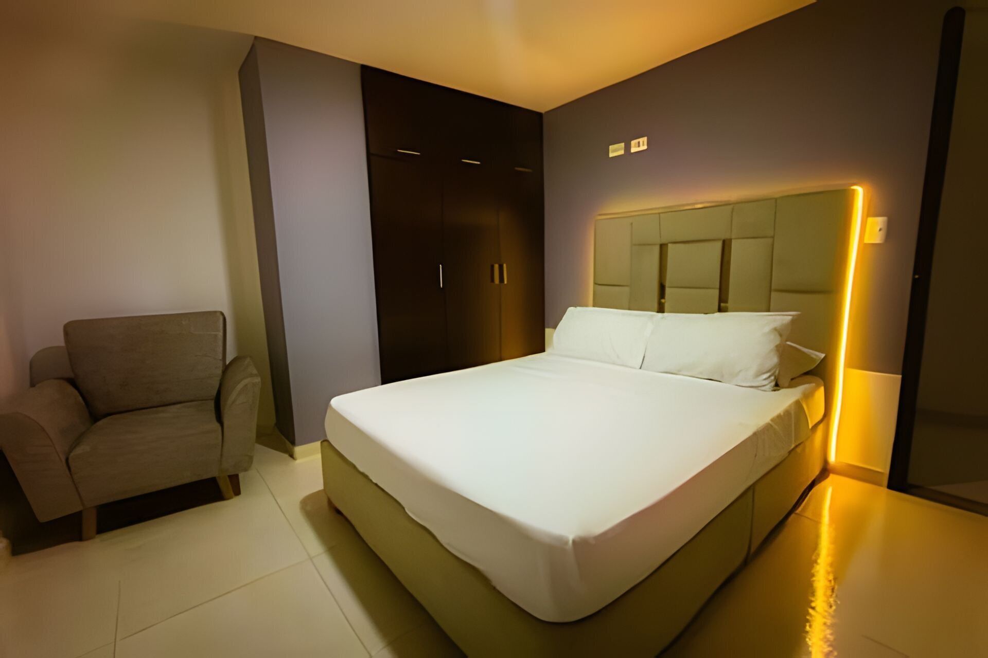 Een moderne hotelkamer met een groot bed, een zithoek en een kledingkast.