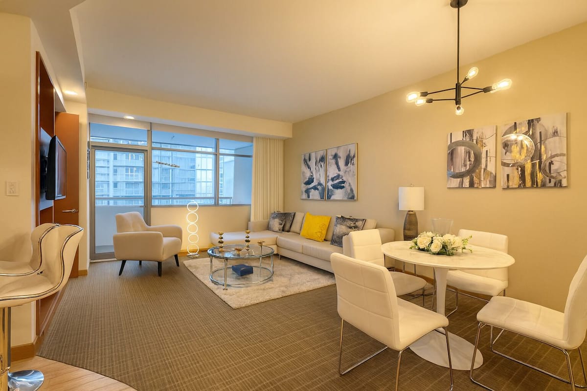 A modern living room with a sofa, chairs, a coffee table, and artwork on the walls.