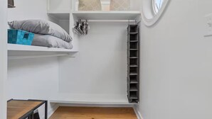 A compact storage unit with shelves and hanging organizers, a small table, and a window. - Peaceful Retreat, Close to the Beach (Pass Christian)