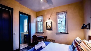 A bedroom with a bed, a desk, and two windows. - The Penthouse Suite - South Main Escape (Buena Vista)