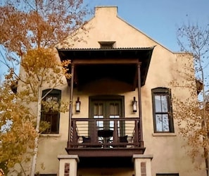 A two-story building with a balcony and a small porch.