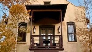 A two-story building with a balcony, a chimney, and a window with a curtain. - The Penthouse Suite - South Main Escape (Buena Vista)